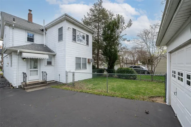 a view of a house with backyard and trees