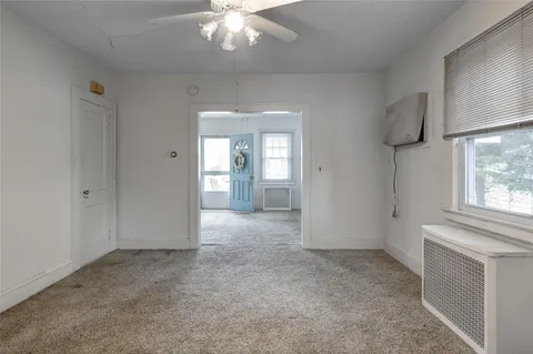 an empty room with windows and cabinet
