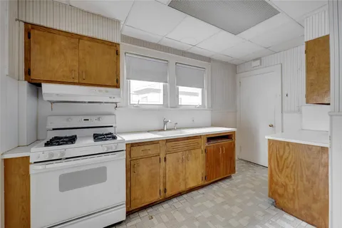 a kitchen with a stove sink and cabinets