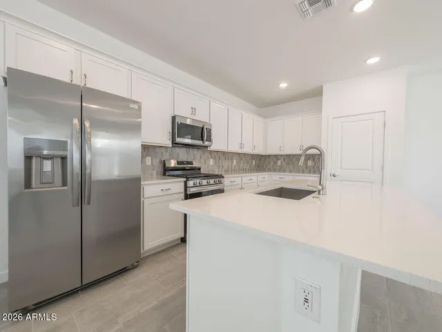a kitchen with a sink window and stainless steel appliances