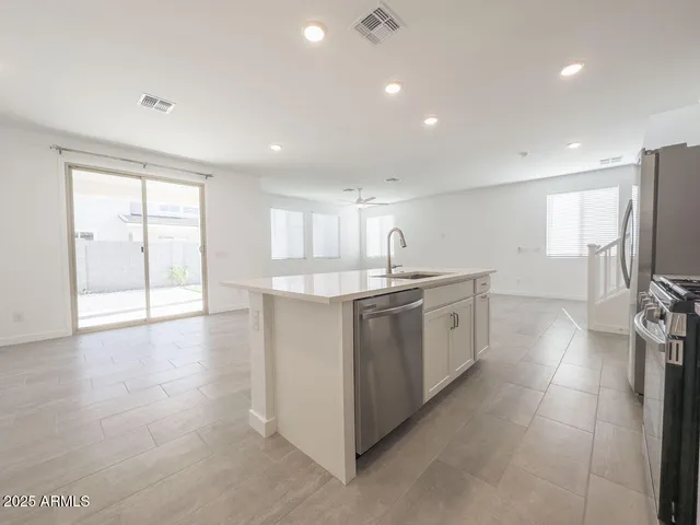a kitchen with granite countertop cabinets stainless steel appliances and a sink
