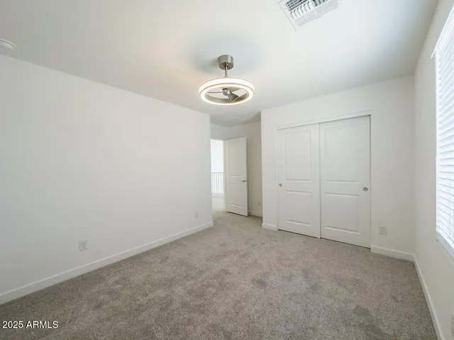 an empty room with windows and closet
