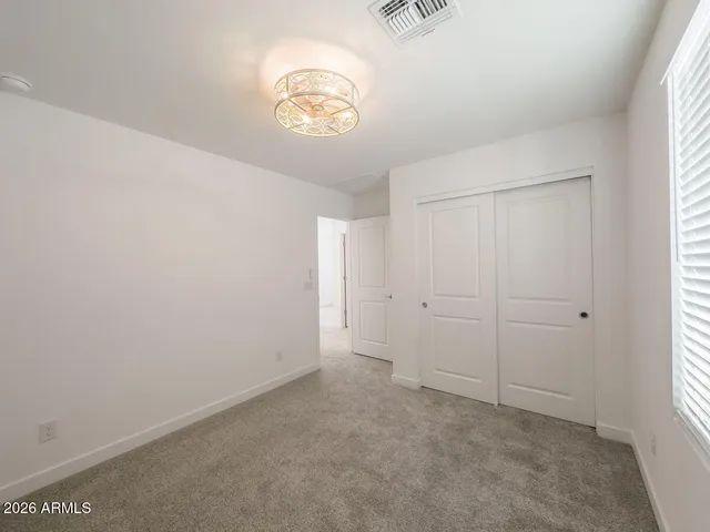 a bedroom with a bed and a flat tv screen on dresser