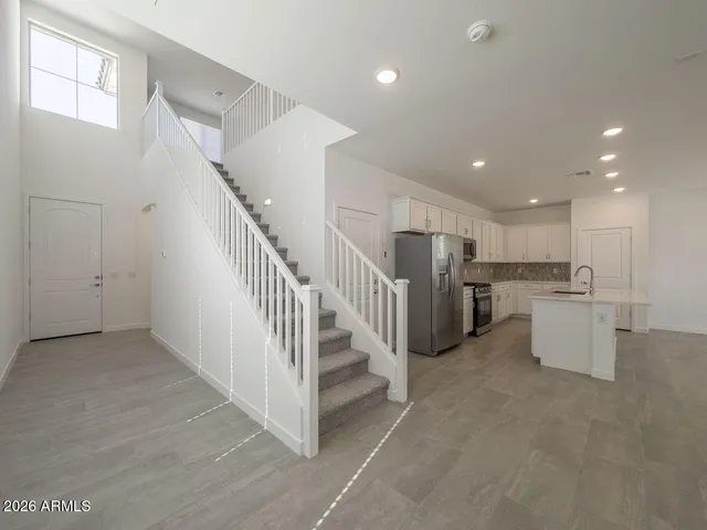 a view of a kitchen with refrigerator and white cabinets
