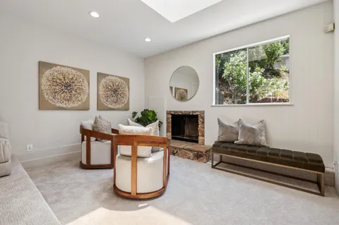 a living room with furniture a fireplace and a window