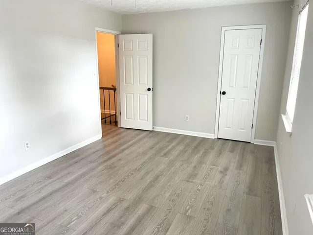 an empty room with wooden floor and closet