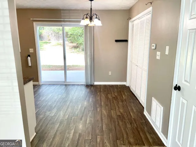 a view of a room with wooden floor staircase and front door