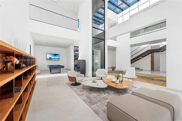 a living room with furniture a flat screen tv and floor to ceiling window
