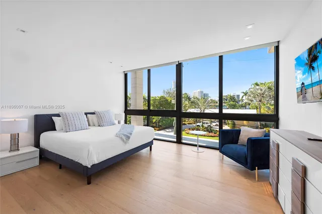 a bedroom with a large bed and a large window with outer view