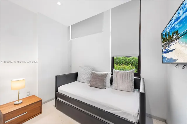 a bedroom with a bed a large window and walk in closet