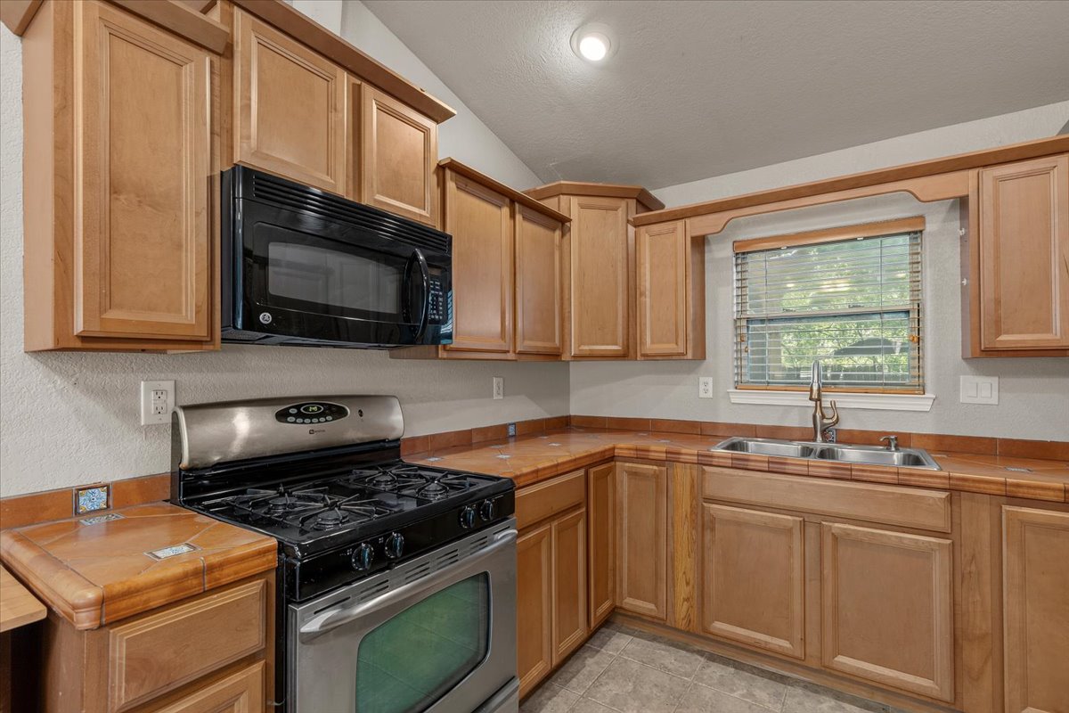 7604 Robalo Road Austin, TX 78757 - Photo 7 of 36 A well-appointed kitchen features ample wood cabinetry and modern appliances for culinary pursuits.