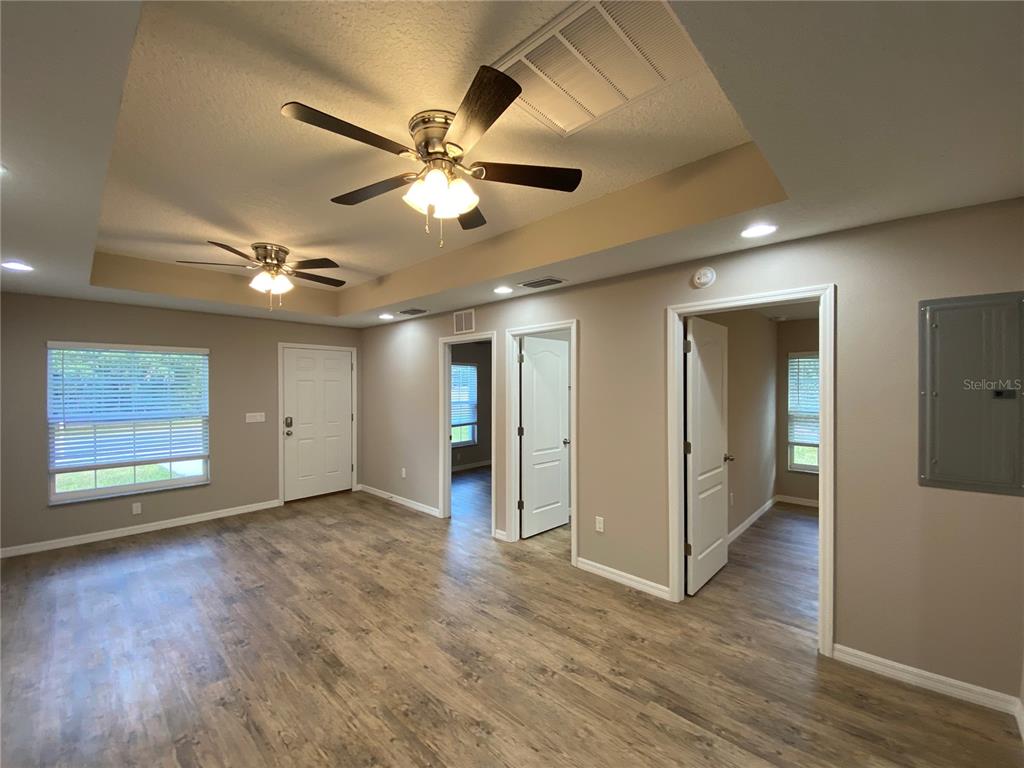 8950 North Mendoza Way Citrus Springs, FL 34434 - Photo 11 of 35 a view of an empty room with wooden floor and a ceiling fan