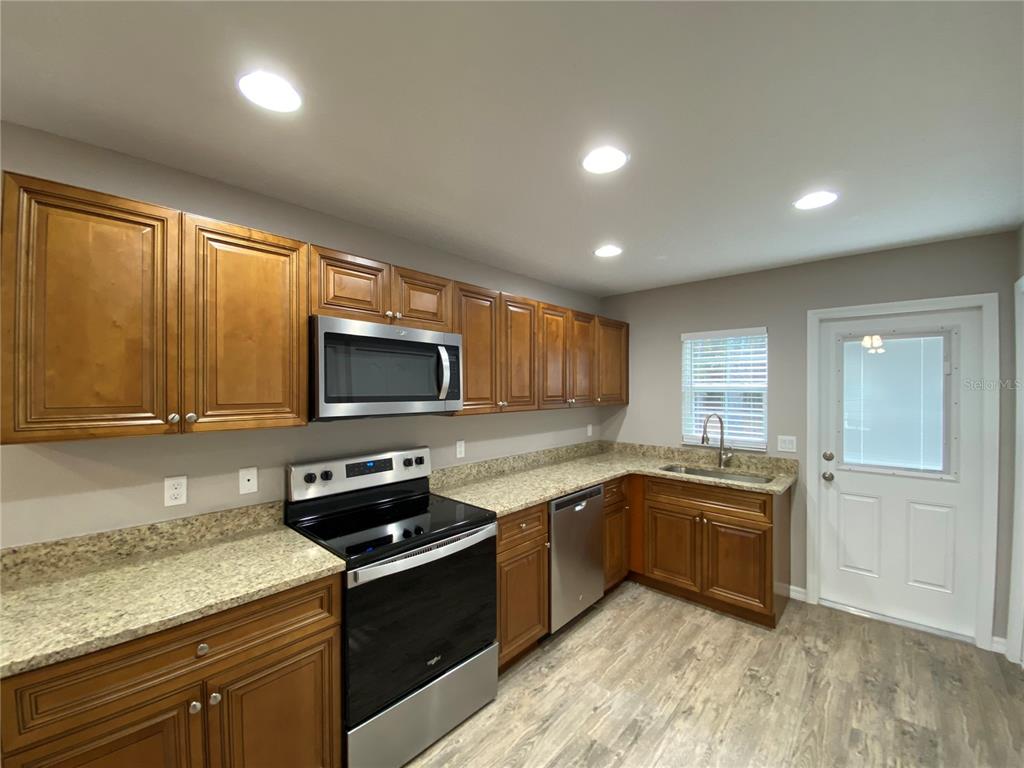 8950 North Mendoza Way Citrus Springs, FL 34434 - Photo 13 of 35 a kitchen with a sink stove top oven and refrigerator