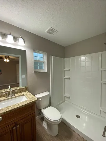 a bathroom with a granite countertop sink toilet and shower