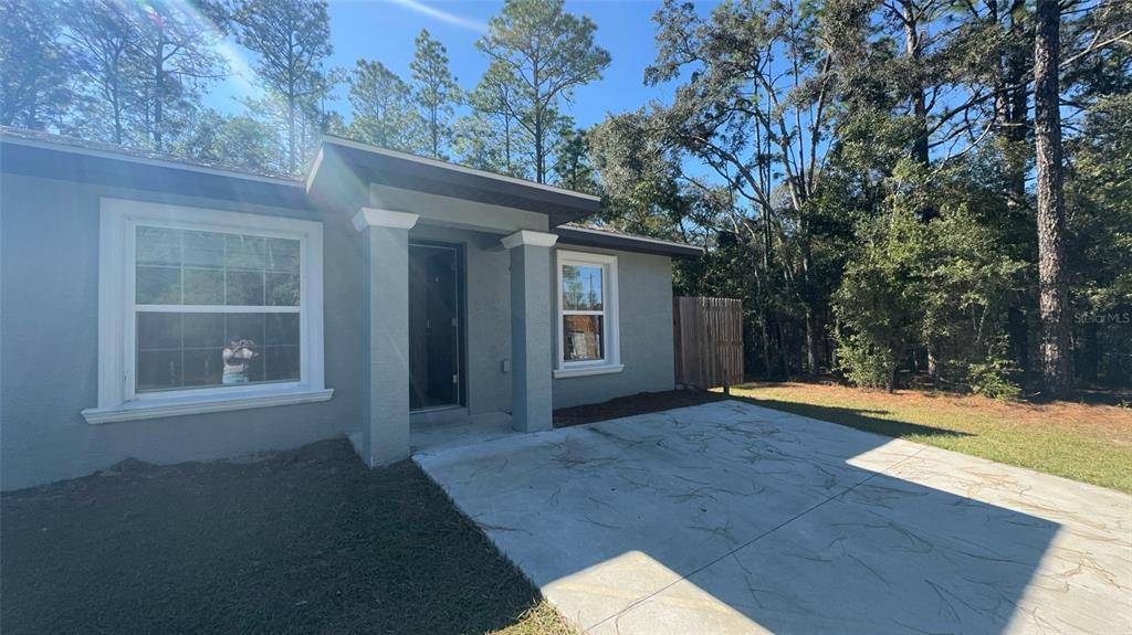 8950 North Mendoza Way Citrus Springs, FL 34434 - Photo 2 of 35 a view of a house with a yard and garage