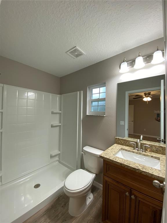8950 North Mendoza Way Citrus Springs, FL 34434 - Photo 26 of 35 a bathroom with a granite countertop sink toilet a mirror and shower
