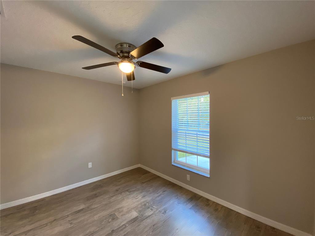8950 North Mendoza Way Citrus Springs, FL 34434 - Photo 28 of 35 a view of an empty room with wooden floor and a window