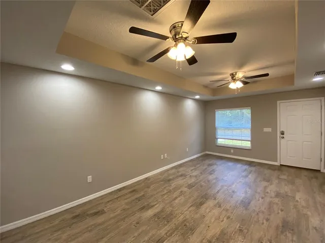 an empty room with fan and windows