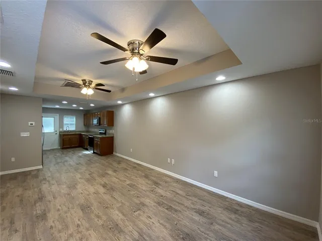 an empty room with a ceiling fan and a window