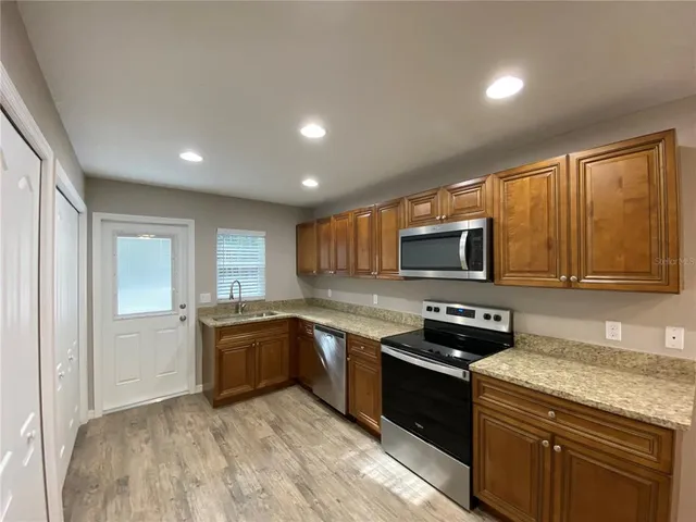 a kitchen with stainless steel appliances granite countertop a stove sink microwave and refrigerator
