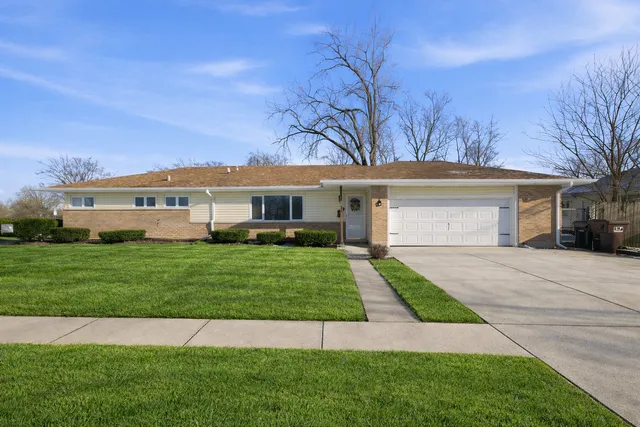 a front view of a house with a garden and yard