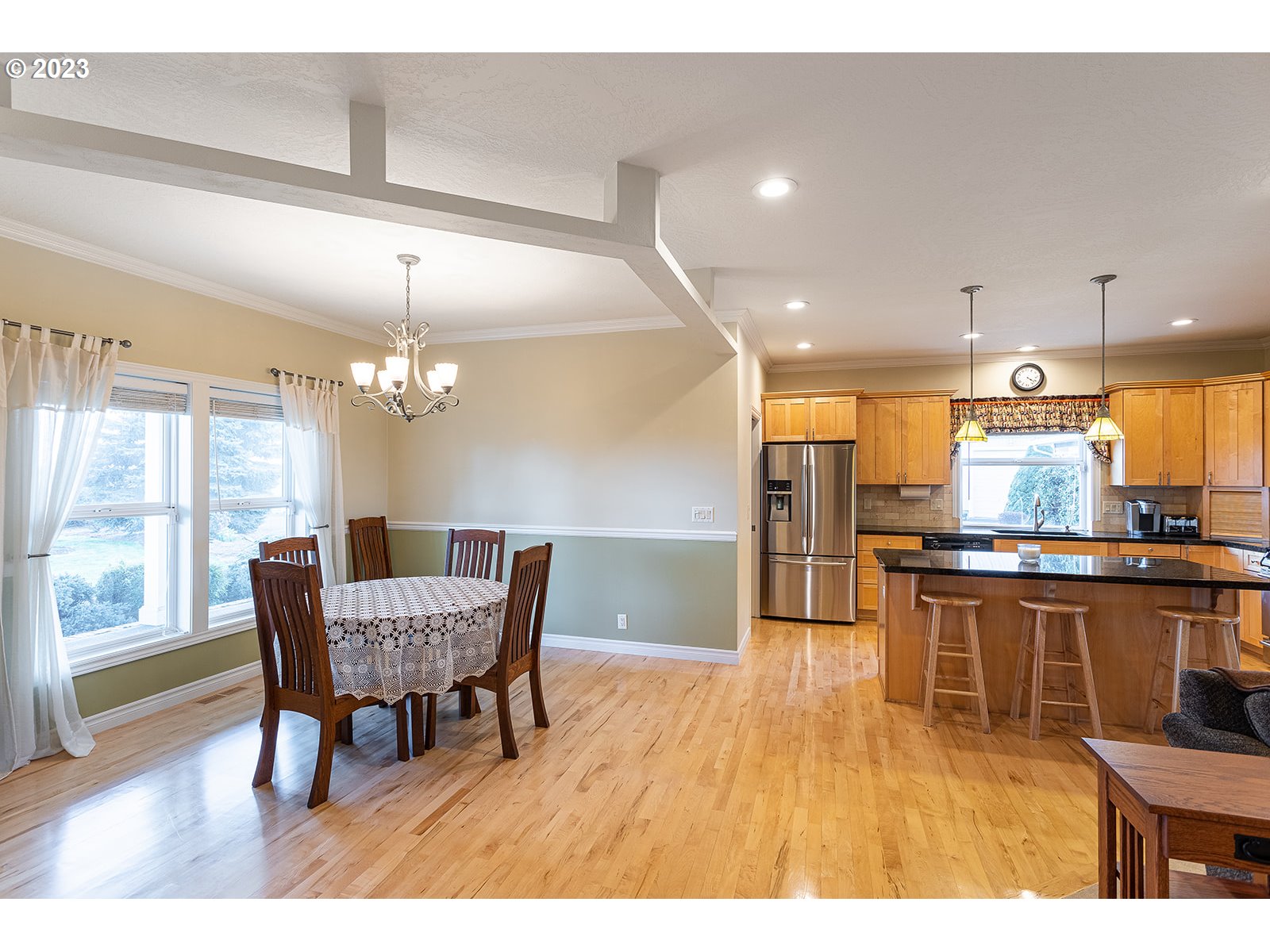 28179 High Pass Road Junction City, OR 97448 - Photo 11 of 48 a open kitchen with stainless steel appliances kitchen island granite countertop a table chairs and a wooden floor