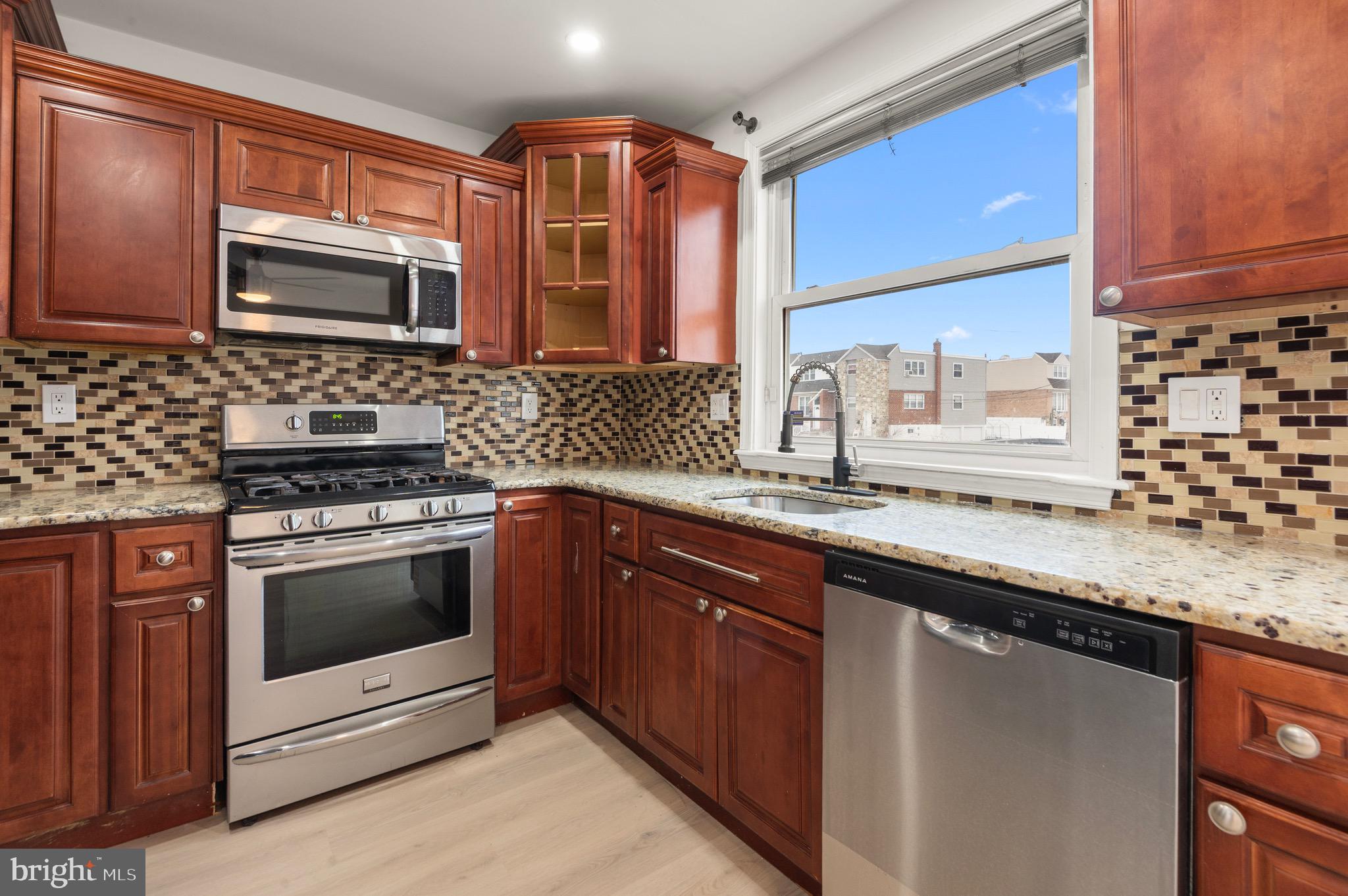 10867 Harrow Road Philadelphia, PA 19154 - Photo 10 of 19 a kitchen with stainless steel appliances granite countertop a sink stove and microwave
