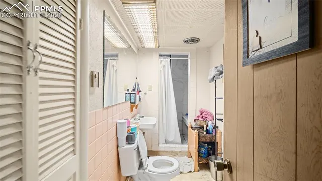 a bedroom with a bed and painting on the wall