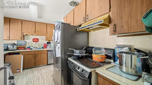 a kitchen with stainless steel appliances a refrigerator sink and cabinets