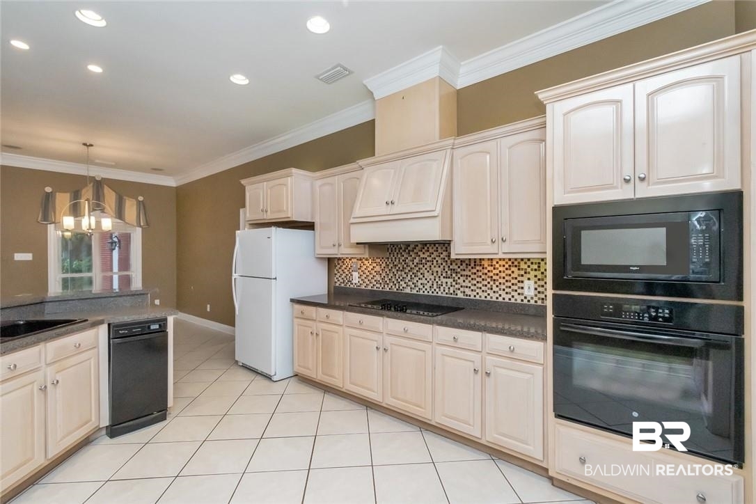 8837 Dawes Lake Road South Mobile, AL 36619 - Photo 10 of 44 Kitchen featuring an inviting chandelier, black appliances, light tile patterned floors, crown molding, and hanging light fixtures
