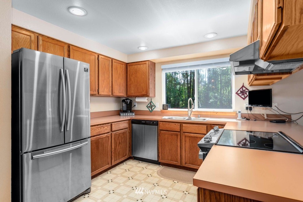 22915 13th Place West Bothell, WA 98021 - Photo 11 of 28 a kitchen with stainless steel appliances granite countertop a refrigerator a sink dishwasher a stove and white countertops with wooden floor