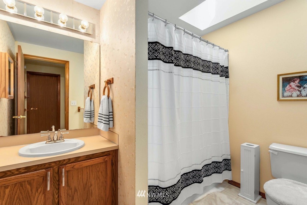 22915 13th Place West Bothell, WA 98021 - Photo 22 of 28 a bathroom with a sink a toilet and a mirror