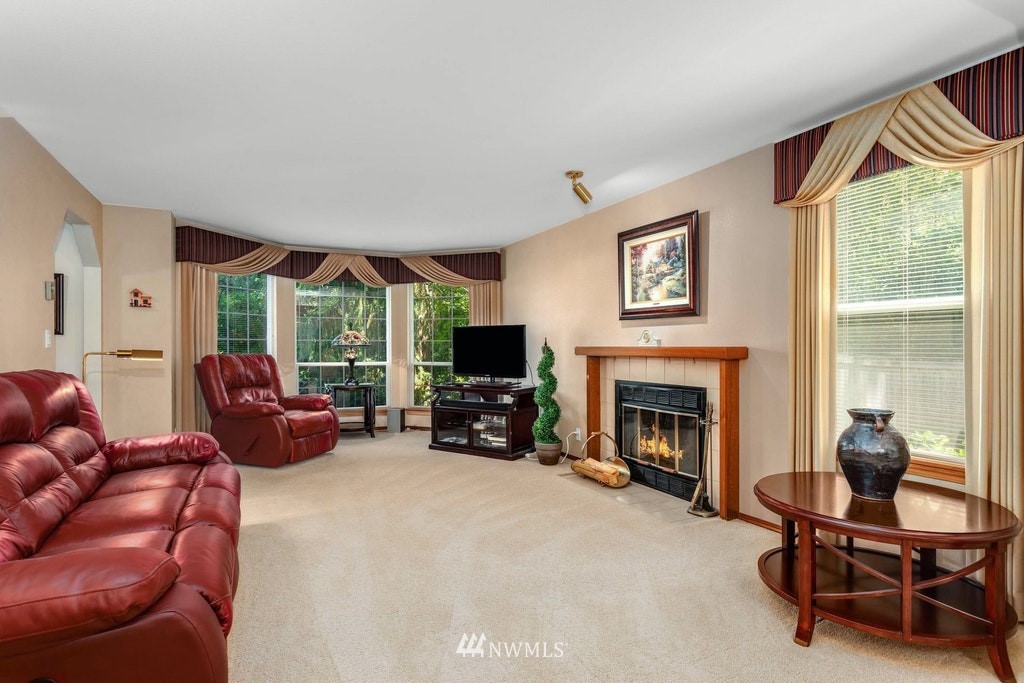 22915 13th Place West Bothell, WA 98021 - Photo 4 of 28 a living room with furniture a fireplace and a floor to ceiling window