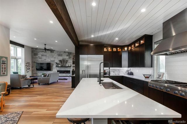 a large kitchen with stainless steel appliances a large counter top a stove and a sink