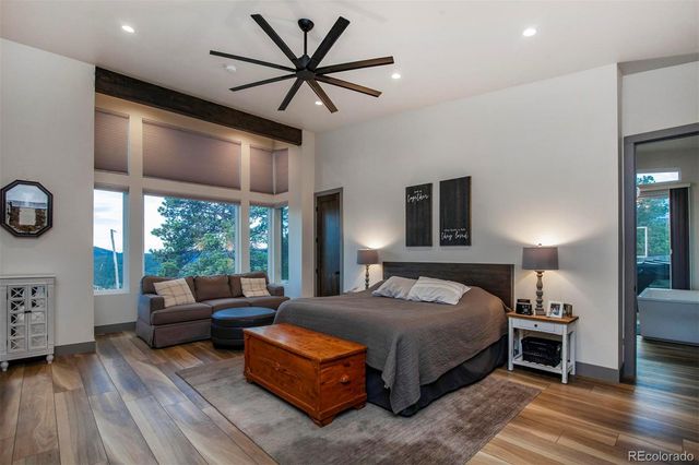 a bedroom with a bed a chandelier and a large window