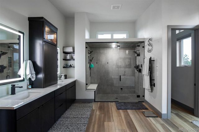 a bathroom with a glass shower door and a sink