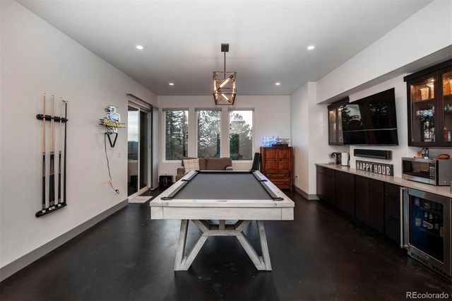 a room with pool table flat screen tv and windows