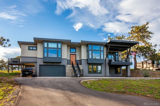 a front view of a house with swimming pool and furniture