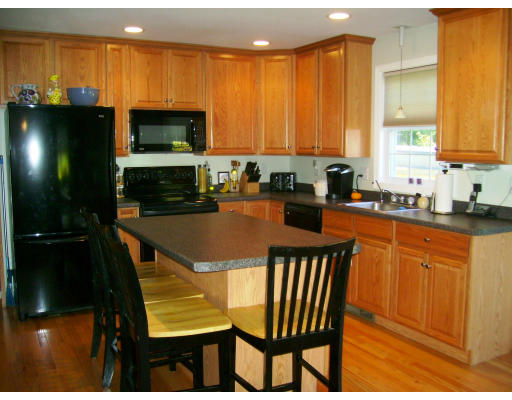 2 April Pepperell, MA 01463 - Photo 3 of 6 a kitchen with a sink a microwave a dining table and chairs