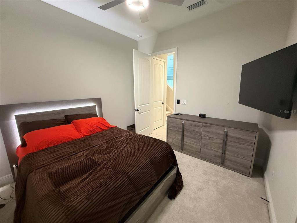 10958 Rustic Timber Loop San Antonio, FL 33576 - Photo 26 of 48 a bedroom with a bed and flat screen tv