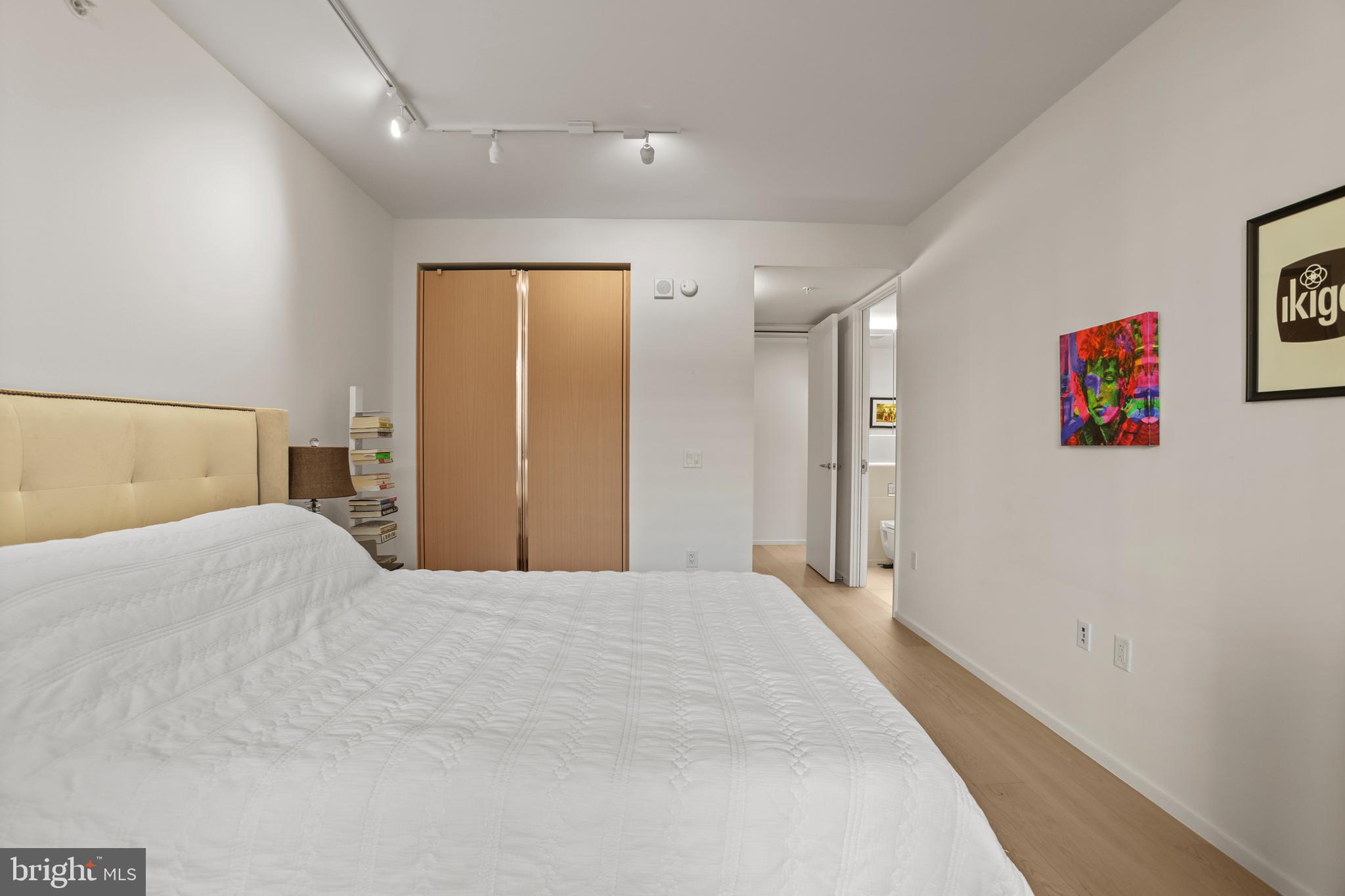 925 H Street Northwest, Unit 712 Washington, DC 20001 - Photo 21 of 54 a spacious bedroom with a bed and painting on the wall