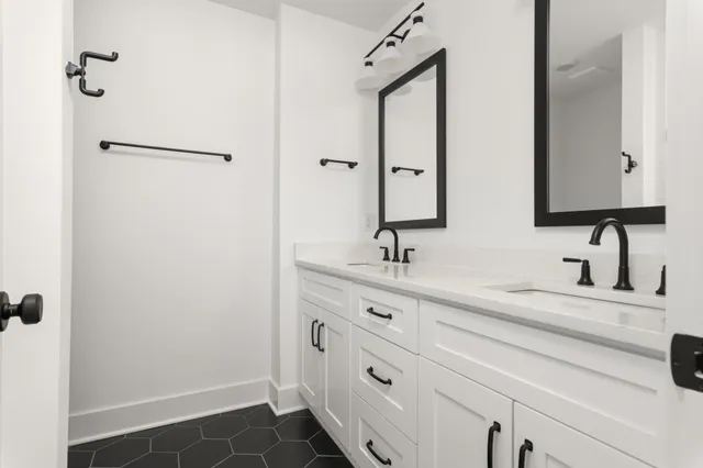 a bathroom with double sink and a mirror