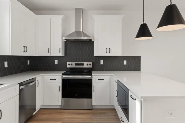 a kitchen with white cabinets and a stove