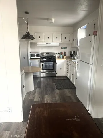 a kitchen with stainless steel appliances granite countertop a refrigerator a stove and a sink