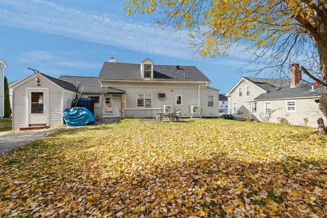 a front view of a house with a large tree