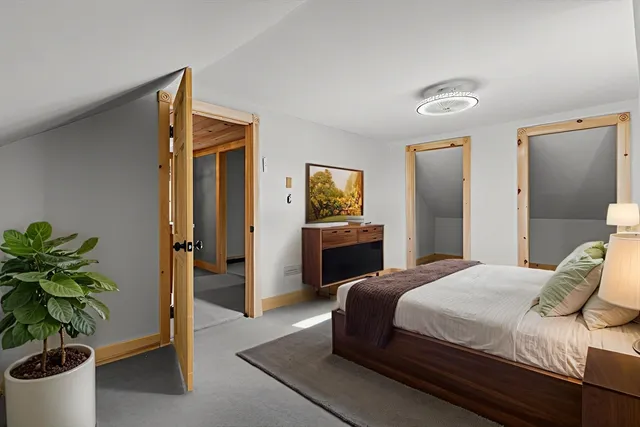 a bedroom with bed and a potted plant