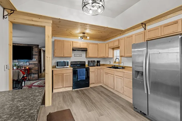 a kitchen with a refrigerator cabinets and wooden floor