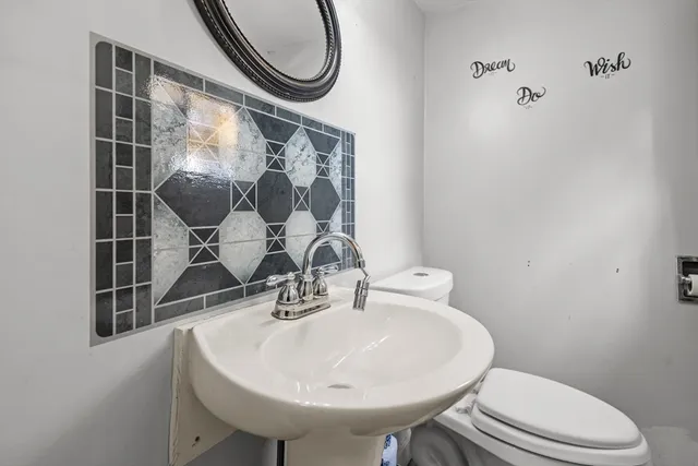 a bathroom with a sink a toilet and a mirror