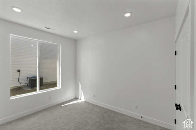 205 East 690th Street North Logan, UT 84321 - Photo 18 of 52 Carpeted room with recessed lighting, a sliding window, and a paneled door with black hardware