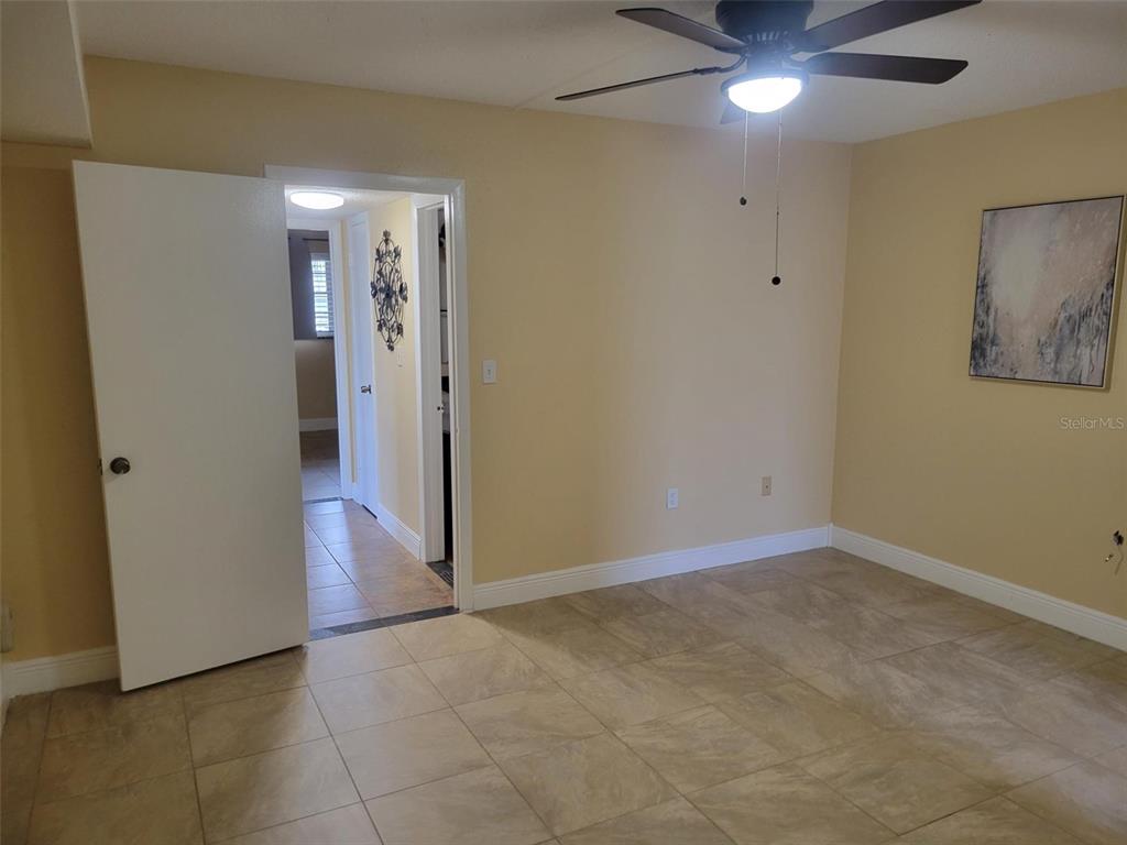 10032 65th Avenue North, Unit 8 St. Petersburg, FL 33708 - Photo 10 of 61 an empty room with closet and a chandelier fan